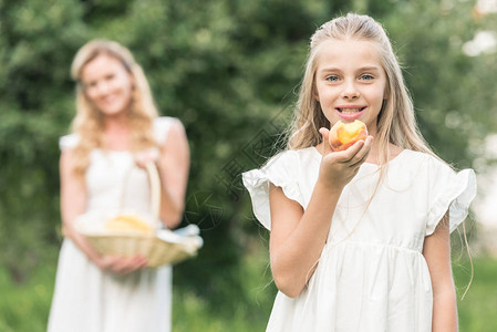 可爱的女儿吃桃子而母亲却在背上图片