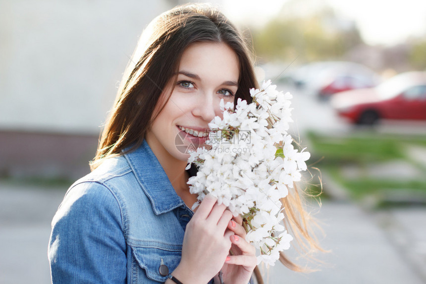 快乐的女人闻着樱花的香味户图片