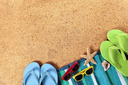 桑迪海滩背景有条纹海滩毛巾海星贝壳飞轮和图片