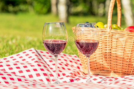 在草坪上野餐两杯葡萄酒和桌布图片