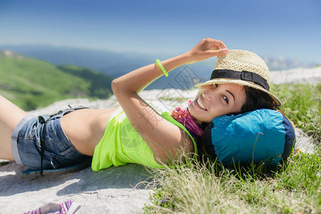 穿草帽带徒步设备旅行的年轻女子正在山上图片