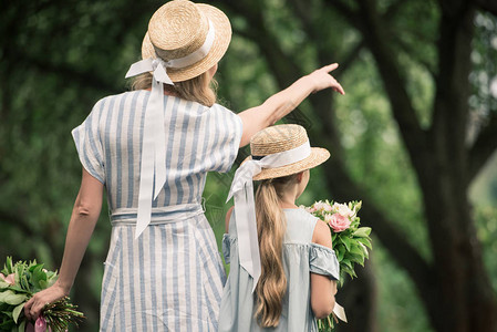 穿着草帽的妈和女儿带着花束妈在公园图片