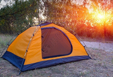日落背景下森林中的旅游帐篷图片