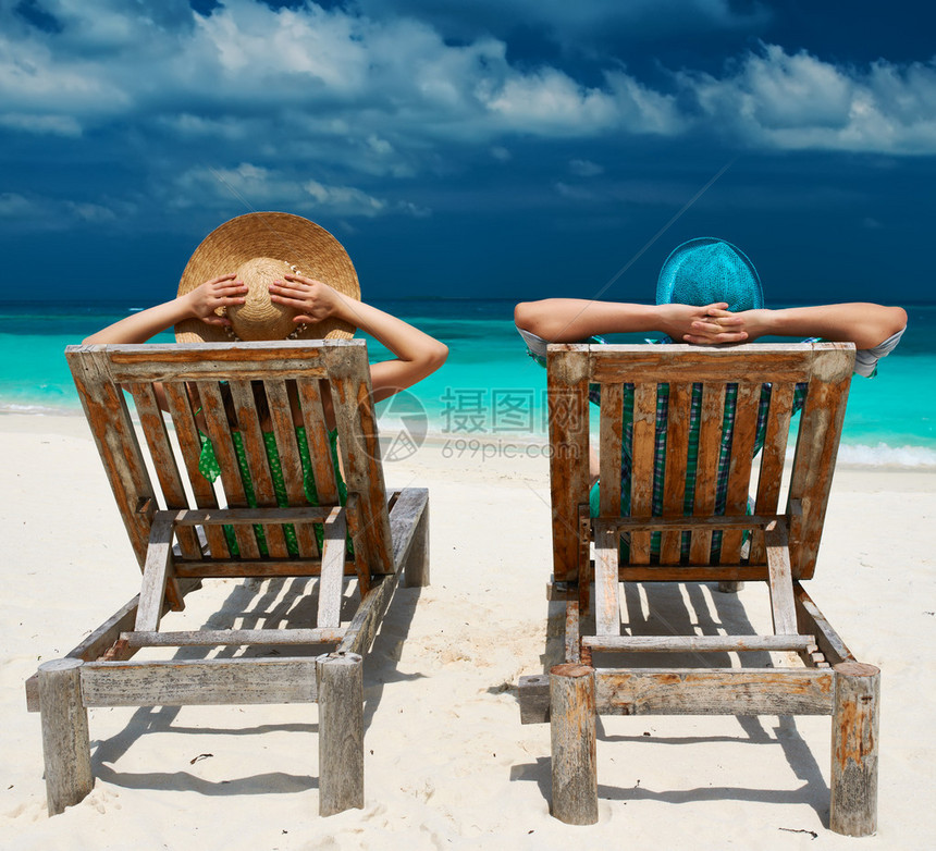 马尔代夫热带海滩上一对夫妇坐在图片