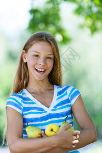 微笑的美丽少女用苹果对抗夏日公图片