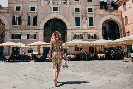 在意大利维罗纳散步的金裙子优雅光脚赤背景图片