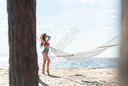 穿着草帽的姑娘在海边摆背景图片