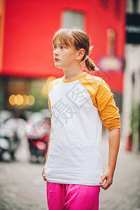 穿黄白长袖棒球T恤衫和明亮粉色短裤的城市年轻少女的户外肖像画Ba图片