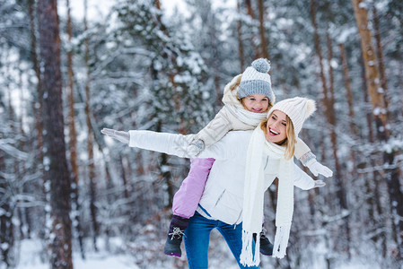 快乐的母亲和小孩在冬季公园一起搭便图片