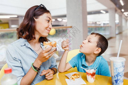 母亲和儿子在购物厅吃快图片