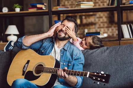 女儿在家里弹吉他时蒙着父亲的眼睛图片