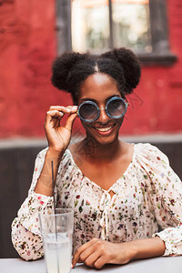 穿着衬衫和太阳镜的美丽微笑的非洲女士图片