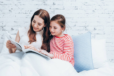家庭幸福母女在床上看书图片