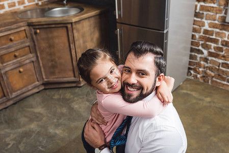 父亲和女儿拥抱厨房的高图片