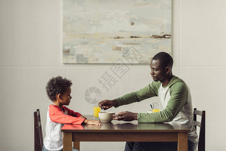 非洲裔美国父子吃早餐的侧视图图片