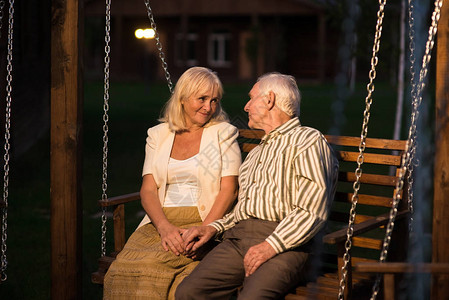 一对夫妇坐在门廊的秋千上老人图片