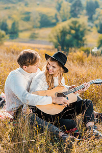 一对微笑的情侣弹吉他和图片