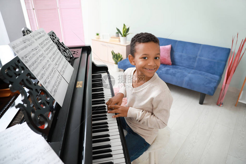 非裔美国小男孩在家里弹大钢琴在家图片