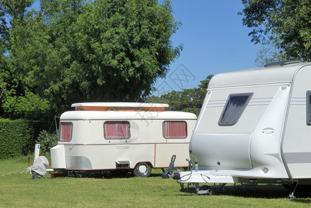 露营中的旧式和现代式大篷车图片