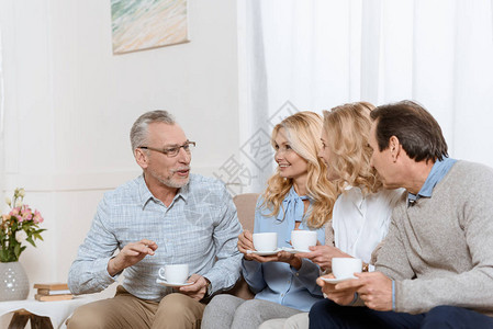 老年男女在沙发上喝茶的同时图片