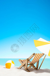 带阳伞的休息椅和海岸上的海滩球有复图片