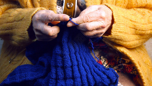 老妇人的手祖母织围巾背景图片