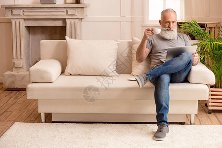 家里坐在沙发上时长胡子老人喝咖啡图片