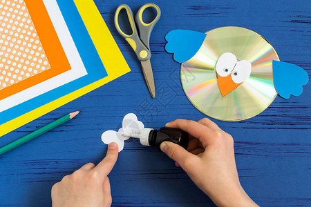 孩子从CD制作鸟儿童艺术项目DIY概念一步的照片说明步骤10儿童用胶图片