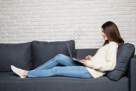 妇女坐在沙发上在客厅的家中图片