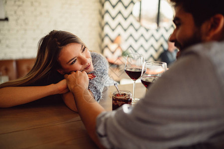 坐在咖啡馆喝红酒的浪漫情侣图片
