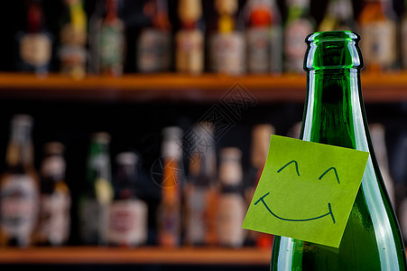 哈喽表情带有微笑表情符号的绿色啤酒瓶背景