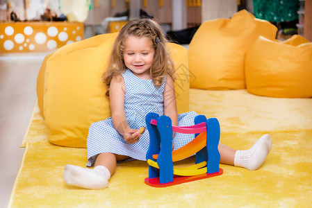 坐在地毯上玩具在幼儿园里玩耍的图片