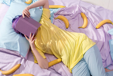 高角度观察躺在床上的香蕉和用书遮图片