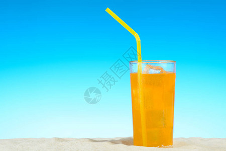 一杯橙汁加冰在沙滩上图片