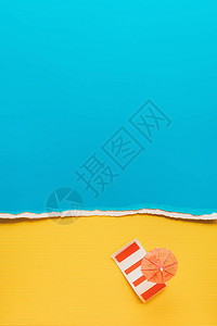 黄色和蓝色纸背景上的小鸡尾酒伞和床上用品的顶部视图背景图片