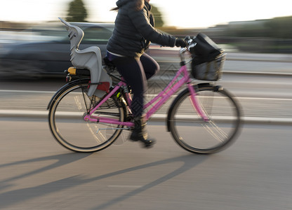 女在粉色自行车上与儿童座椅图片