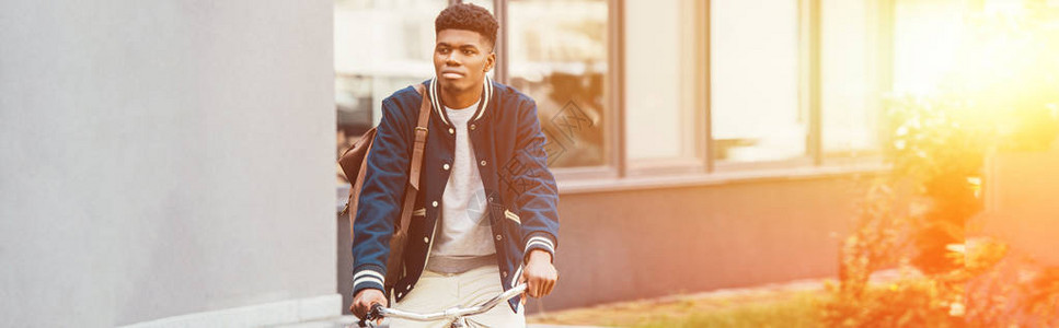 时尚的非裔美国人在城市骑自行图片