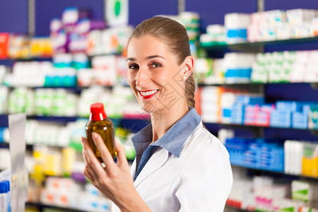 女药剂师站在柜台后药店的药店里图片