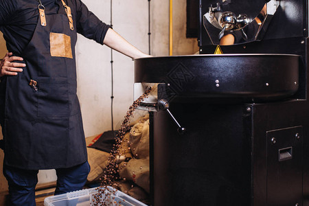 新鲜的烤咖啡豆从一个大咖啡烘烤机图片