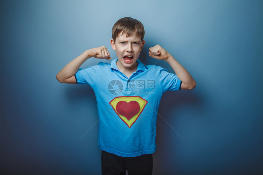 男孩超级英雄的少年举起他的双臂高喊力量赋图片