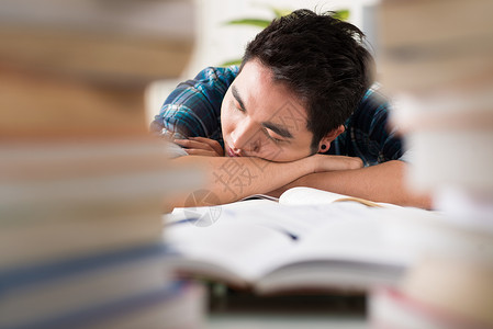 一男学生在大学图书馆露天午睡的近视图像图片
