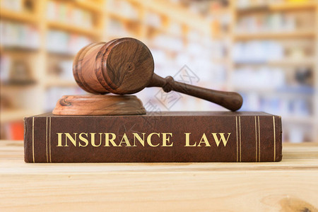 图书馆的桌子上有法官木槌的保险法书籍保险法律法律书籍图片