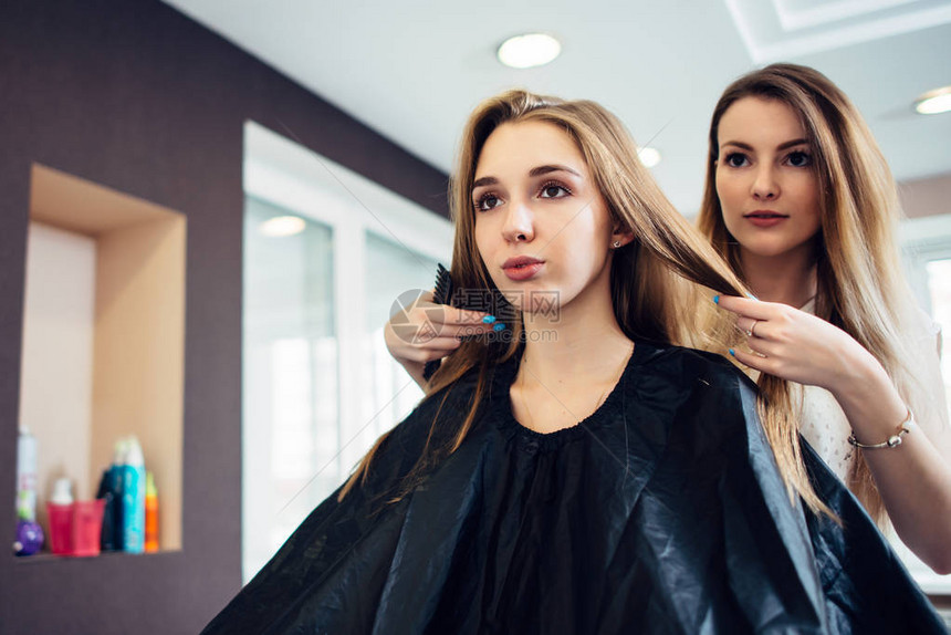 发型师与年轻女顾客决定在美发厅剪什么发型两个漂亮的金发女图片