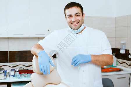 牙科诊所一位微笑的牙医靠在牙图片