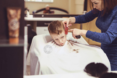 理发店的小男孩子害怕理发美发师的手给小男孩图片