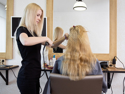 女理发师用造型器做女人的发型图片