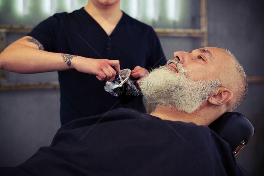 理发师店的一位年长男子用刷剃图片