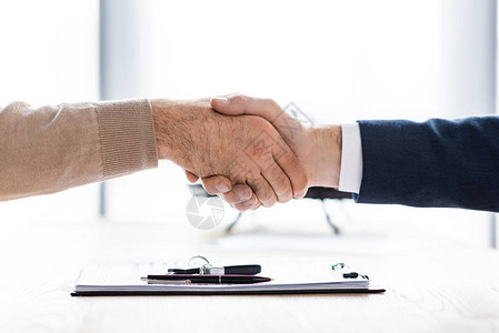 男人和汽车经销商在办公室握手的剪影图片