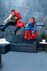 英雄出少年父亲和儿子穿着超英雄服装在背景