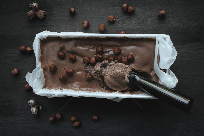 带有自制巧克力冰淇淋和榛子的托盘的顶部视图图片